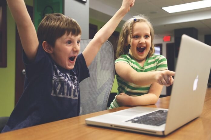 crianças se divertindo nas medias sociais no laptop.