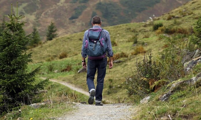 homem fazendo caminhada em uma montanha.