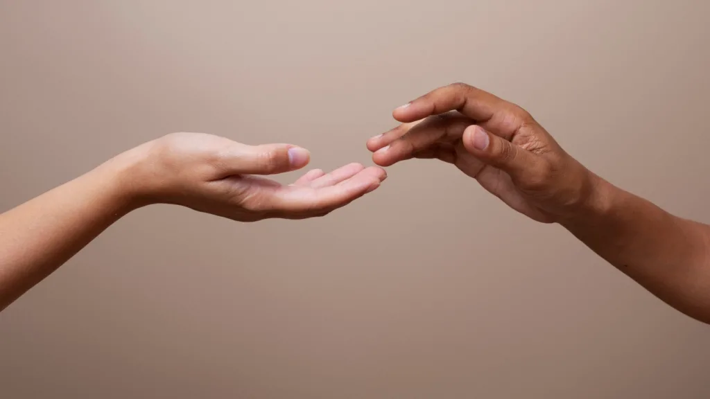 duas mãos se tocando om as pontas dos dedos.