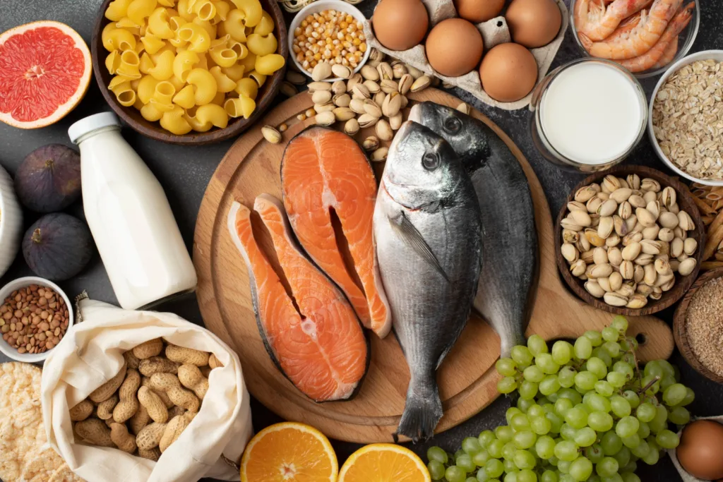 mesa com vários alimentos fonte de vitamina D , in natura como salmão, ovos e grãos.