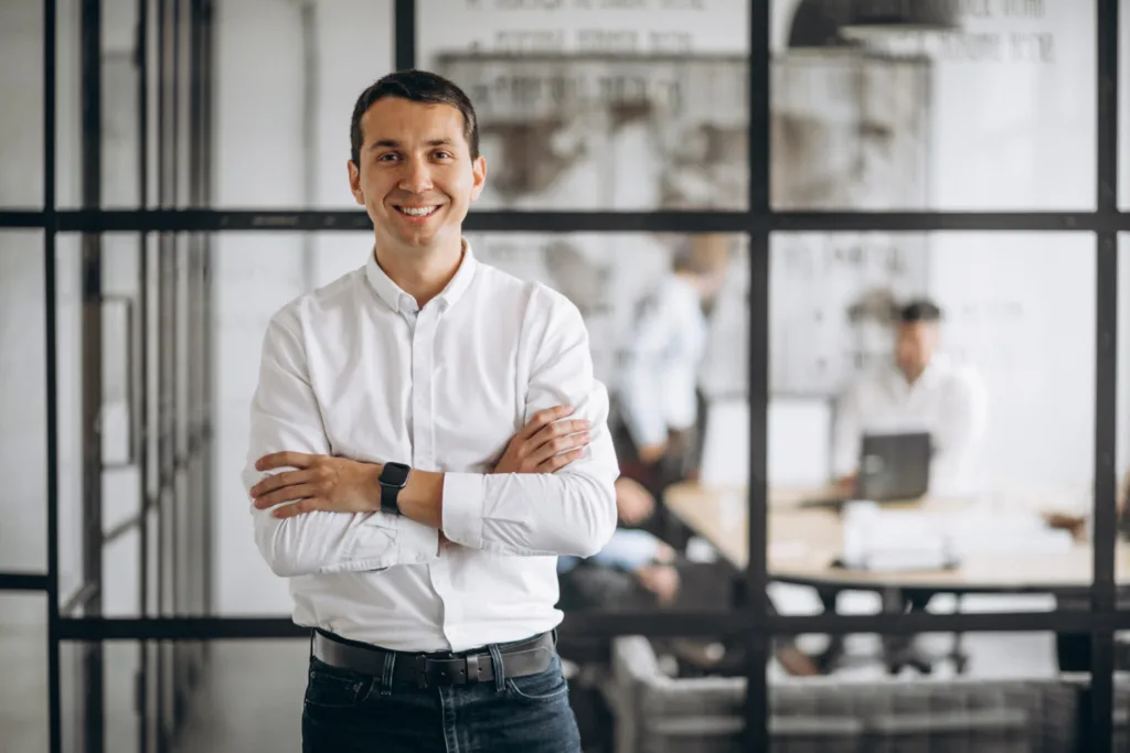 homem de negócios em seu escritório, posando de braços cruzados.
