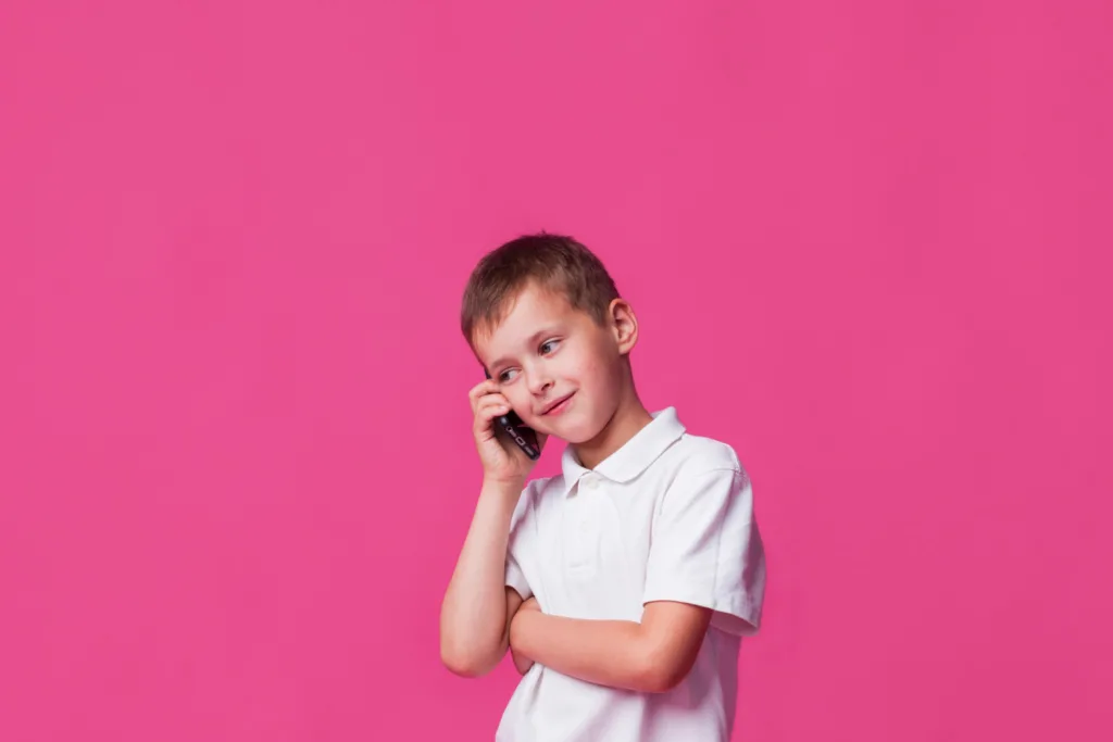 menino usando um telefone celular.